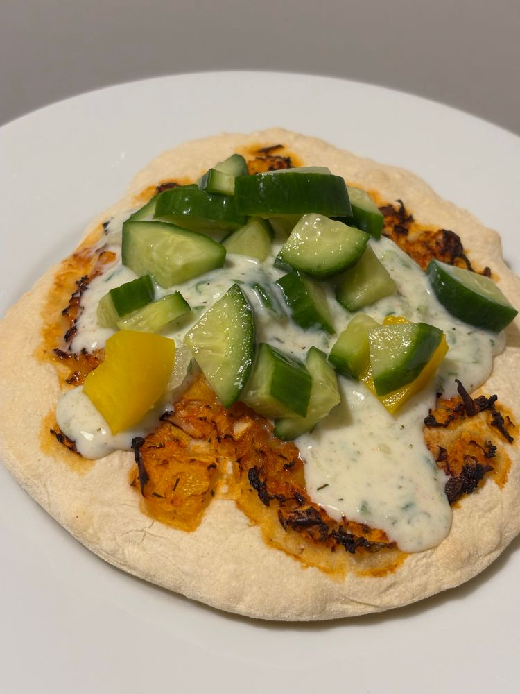 A piece of homemade bread with bell pepper and tomato paste. Vegan garlic sauce with cucumber and bell pepper salad! Delicious!