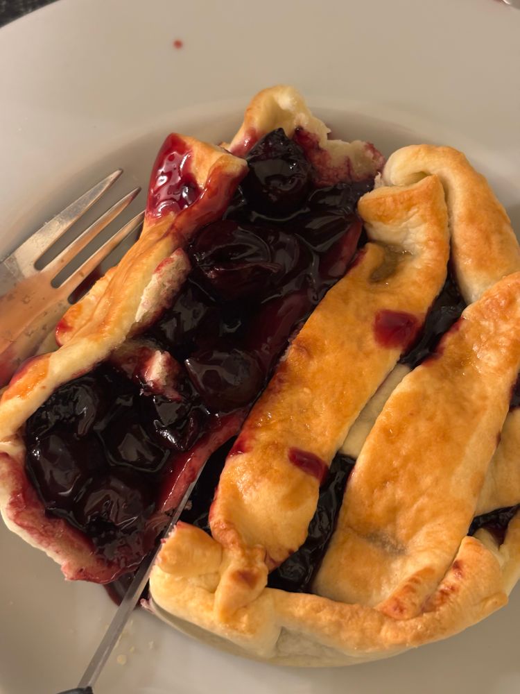 The same cherry pie cut open. The deep red glossy cherries are shiny and sticky looking. Something something Twin Peaks.