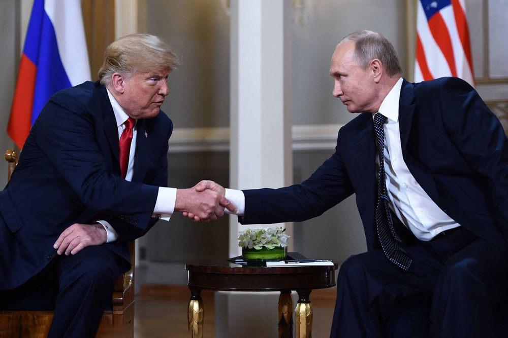  Russian President Vladimir Putin (R) and US President Donald Trump shake hands before a meeting in Helsinki, on July 16, 2018. (BRENDAN SMIALOWSKI/AFP via Getty Images) 