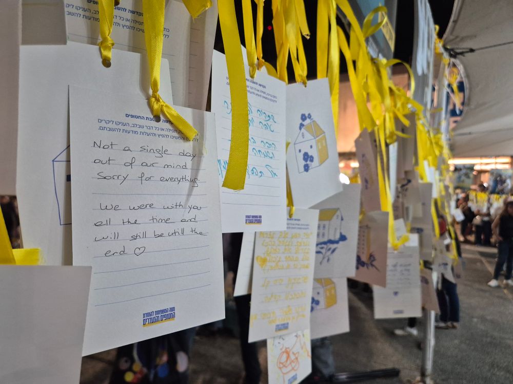 Handwritten signs hanging from yellow ribbons hanging all over the Hostages Square. 