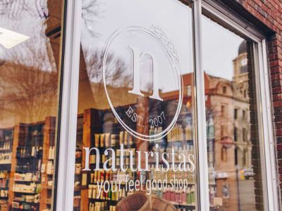 A photo of the front windows of the Naturistas store.