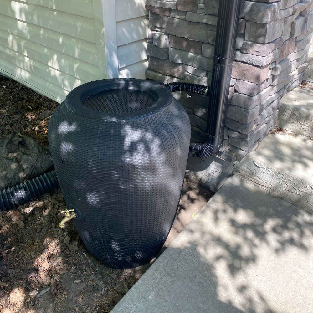 A rain barrel beside a house