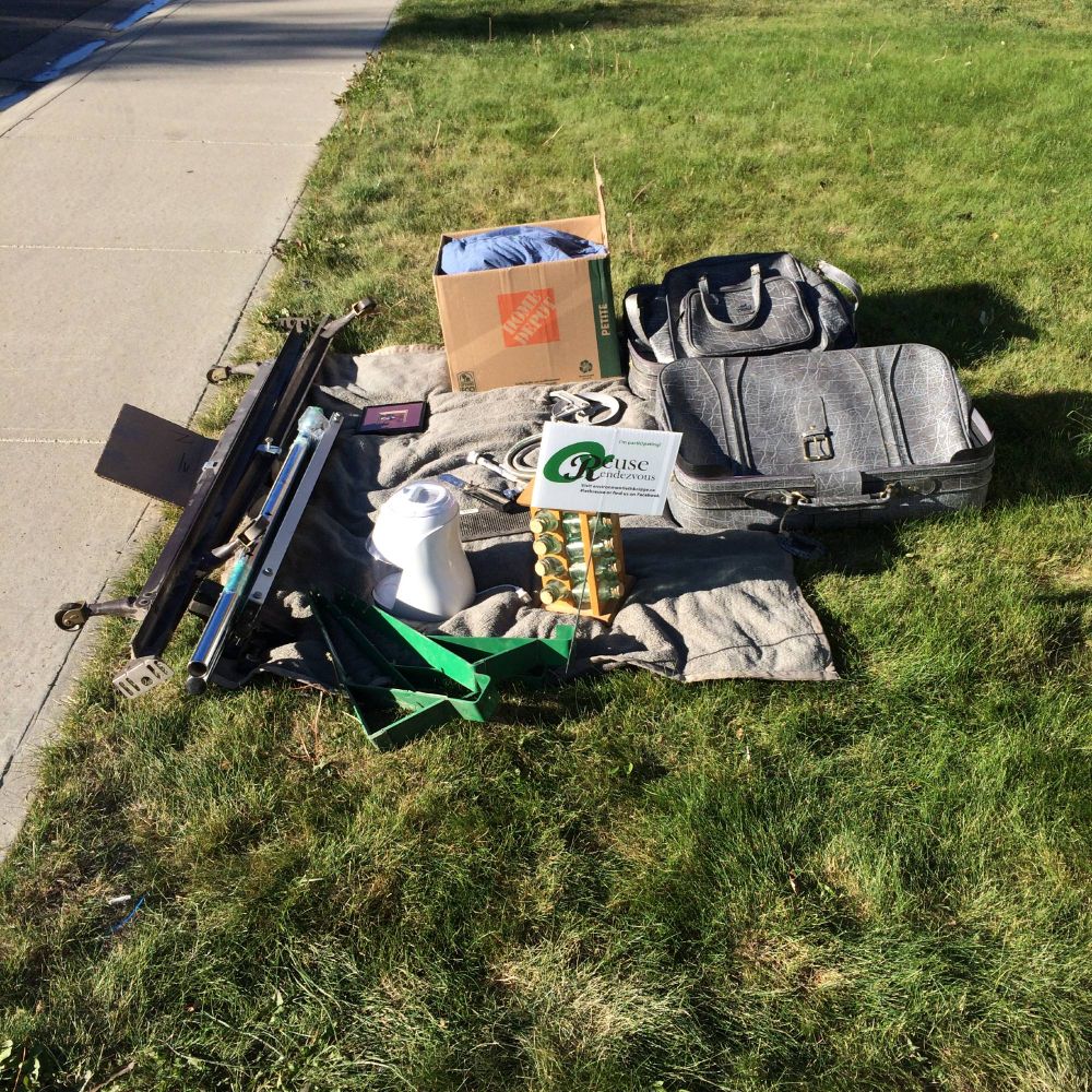 A pile of boxes and other items on a lawn, ready to be given away to a new home