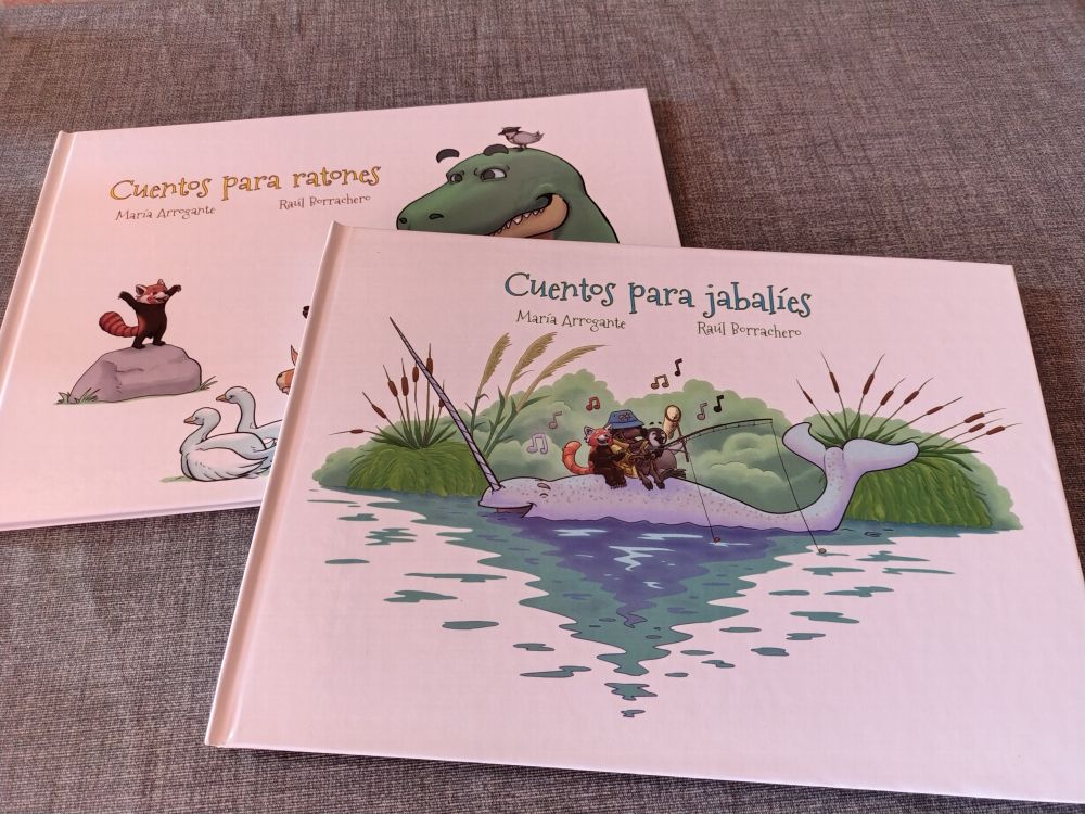 Dos libros, debajo está cuentos para rayones, donde un panda rojo le cuenta cuentos a varios animales (aunque no se ve porque...) encima está Cuentos para jabalíes, donde él panda rojo, un jabalí con un sombrero de pescador y un pingüino, pescan y cantan encima de un narval feliz