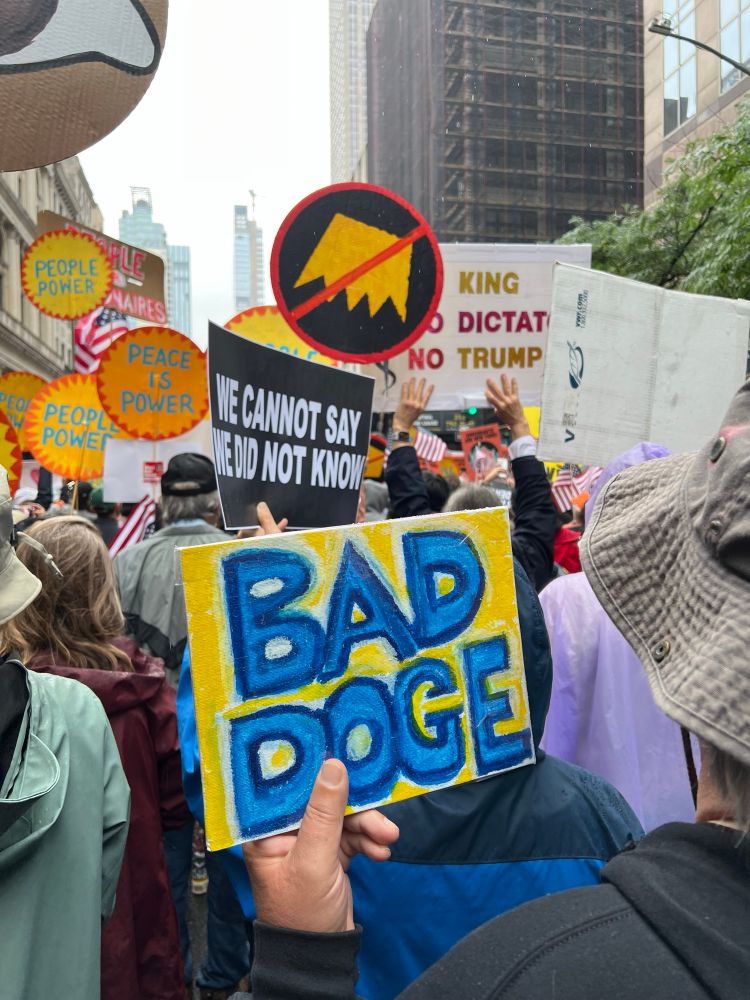 Handwritten sign with “Bad Doge” & a preprinted sign with “We cannot say we did not know”