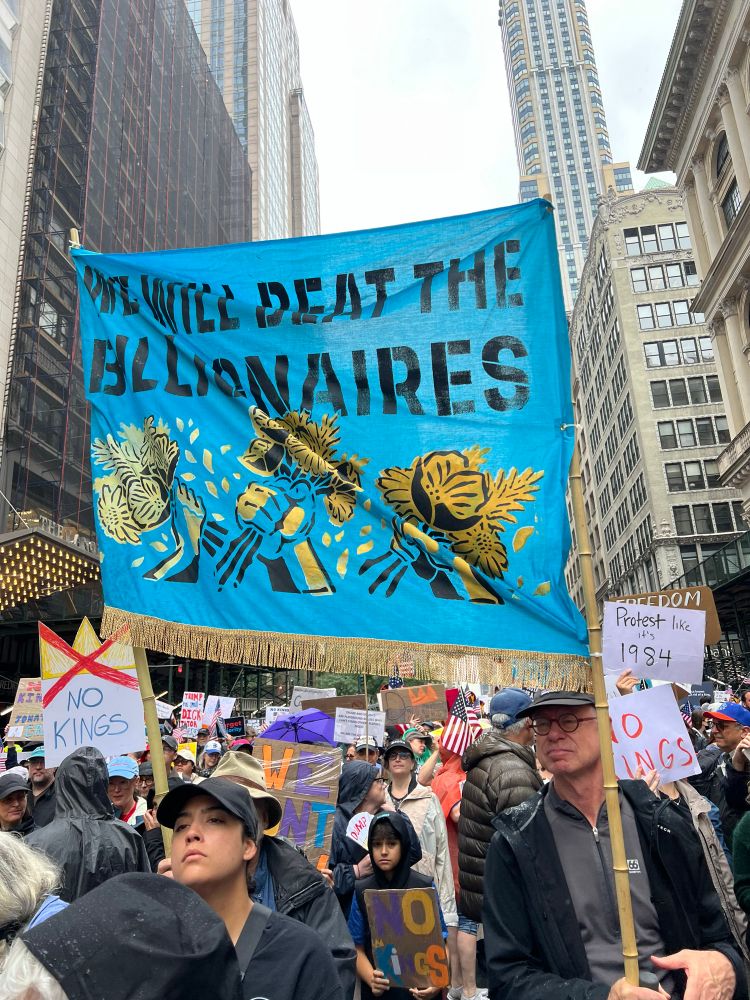 Huge teal banner with @We will beat the Billionaires” on it