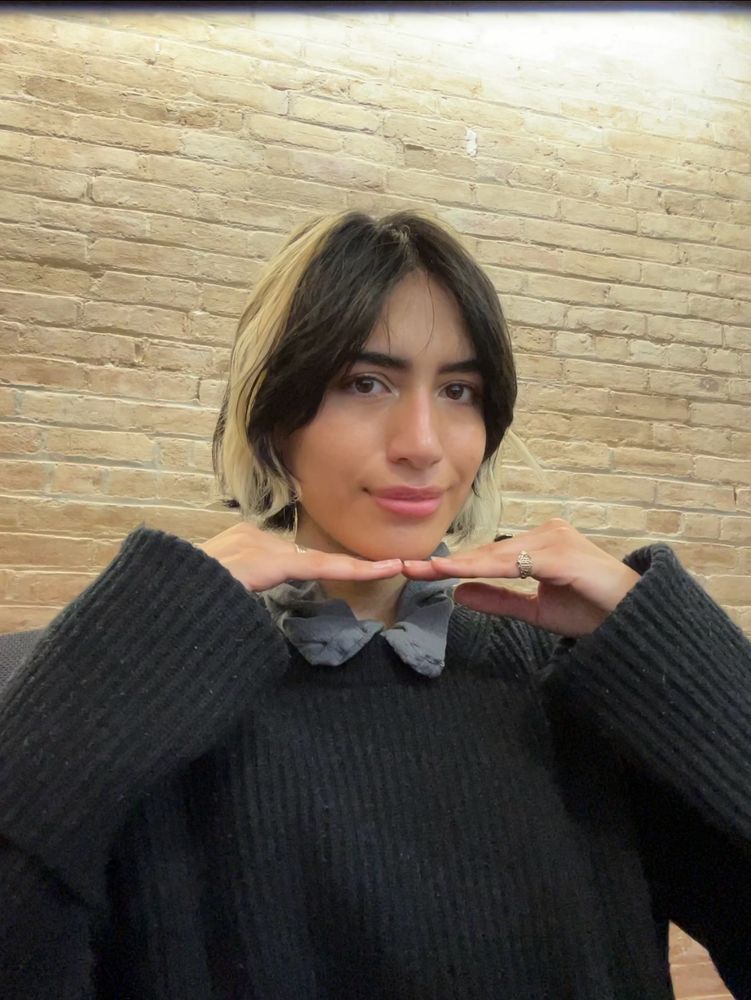 Woman smiling softly with hands placed under face