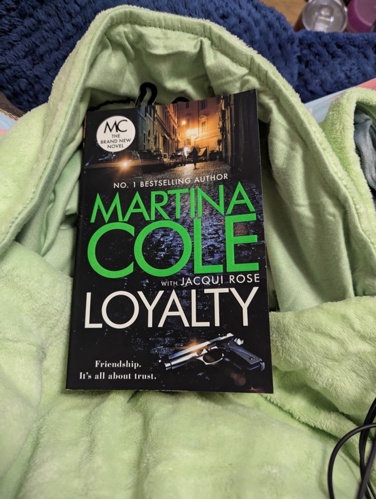 Current read book Loyalty by Martina Cole and Jacqui Rose in my Oodie pouch