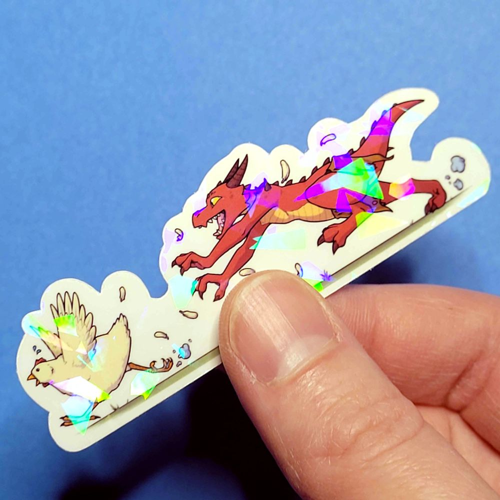 A holographic sticker is held above a solid blue background. The sticker shows a profile view of a red kobold in a loin cloth happily chasing a cream colored chicken, feathers floating around them both as they run. 