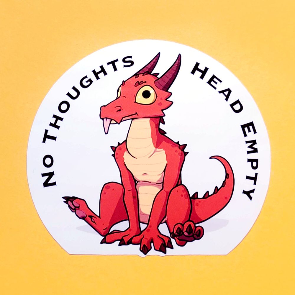 A photo of a sticker showing a red kobold sitting comfortable with a derpy expression (spaced out eyes with their tongue sticking out). The phrase "No Thoughts, Head Empty" curve around the edge of the sticker. The sticker is shown on a yellow background.