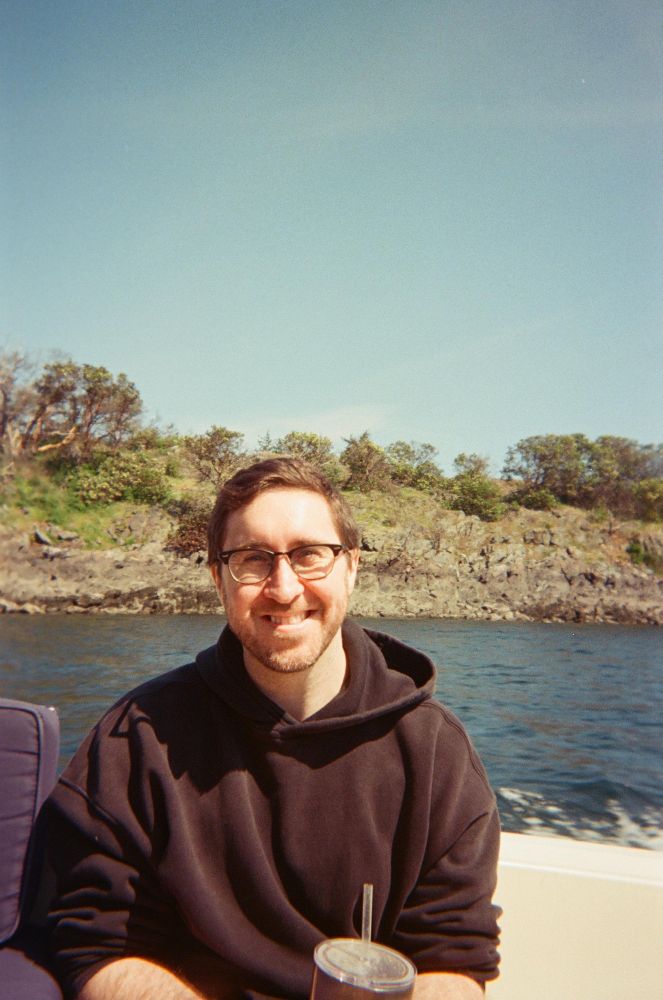 Myself out on a boat driving past an island. 