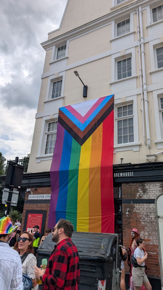 A giant LGBTQ+ flag on a building.