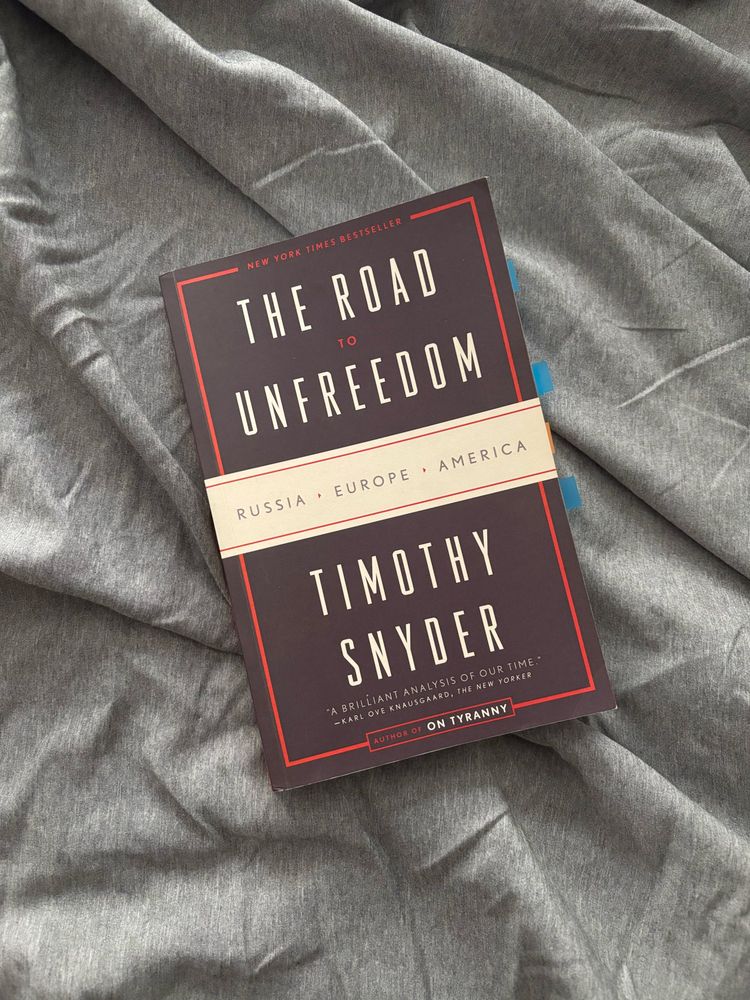 Image of the book “The Road to Unfreedom” by Timothy Snyder on a wrinkled fabric background 