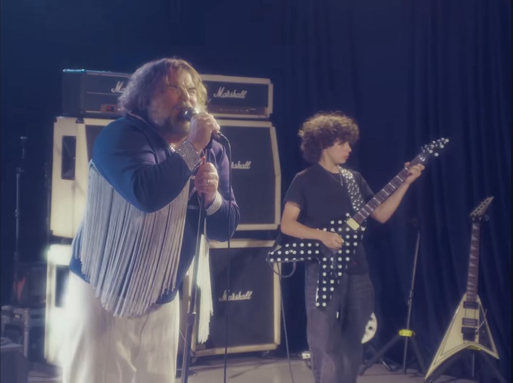 Jack Black singing and Roman Morello playing a polka dot guitar