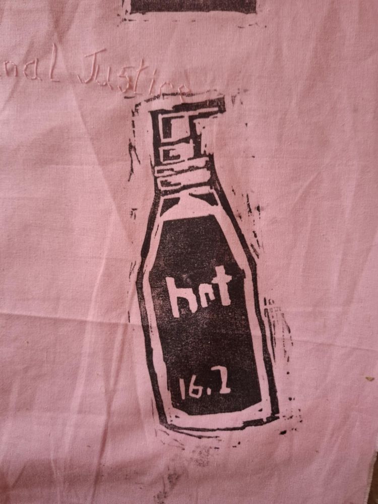 A black printed image on a pink background. The image is of a bottle with a pump on top. The bottle has HRT and 16.2 written on it. 