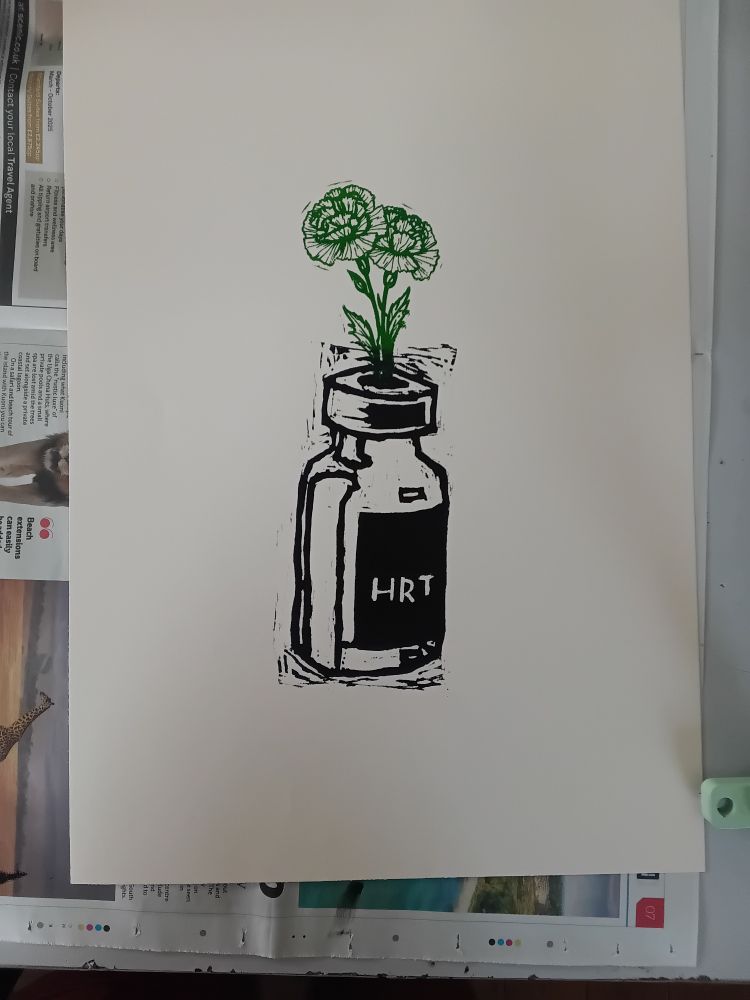 A cream coloured peice of paper with a lino printed image on. The image is of a vial labeled HRT, printed in black. With a carnation flower, printed in green coming out of it