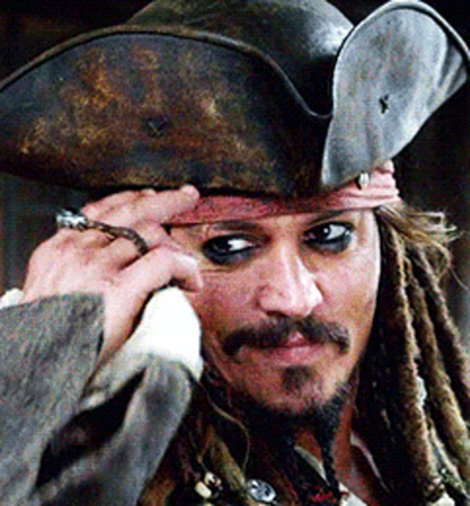 a man with dreadlocks is wearing a pirate hat and a ring on his finger