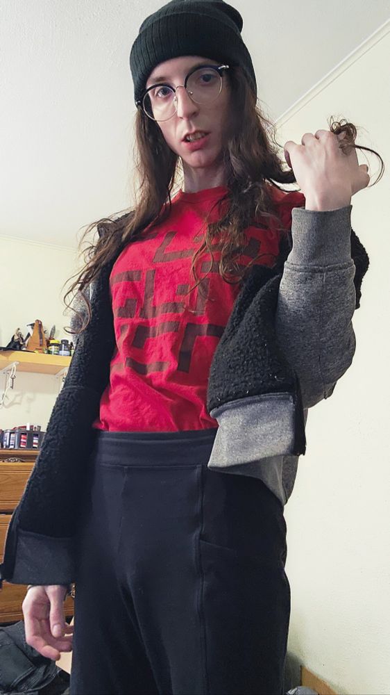 nearly identical to the first pic description, but instead of her left hand up neutrally - she's now twirling her hair with it