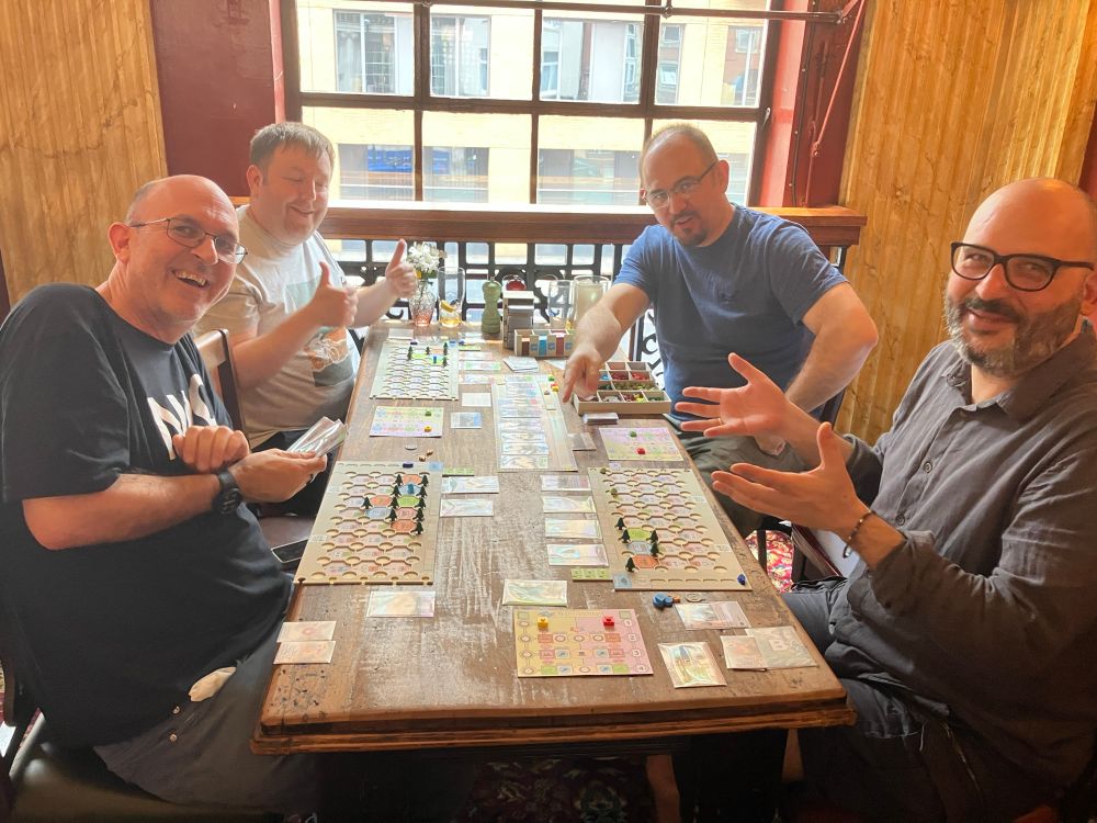 A game prototype being played by four smiling playtesters 