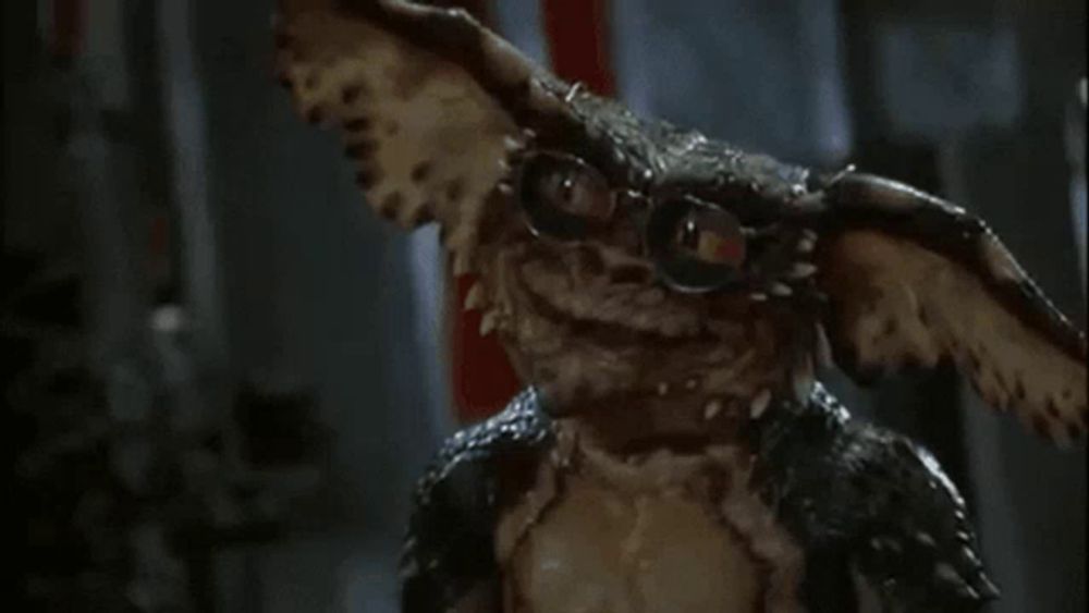 a close up of a gremlins character wearing glasses .