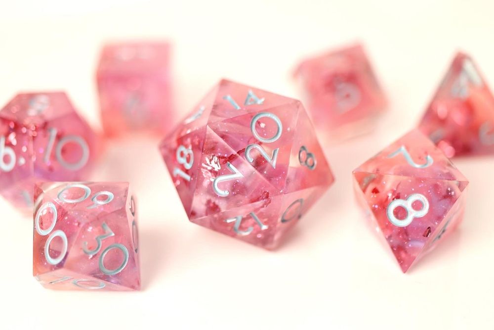 A bright pink dice set with swirls of pastel pink cloud and shimmering pink leaf. Inked with light blue.