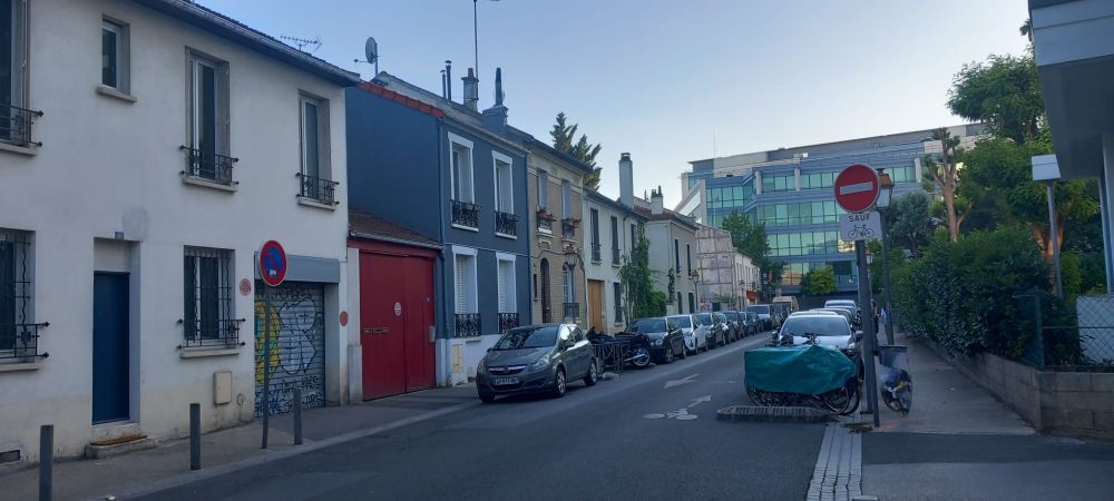 a street with a row of small shuttered houses 