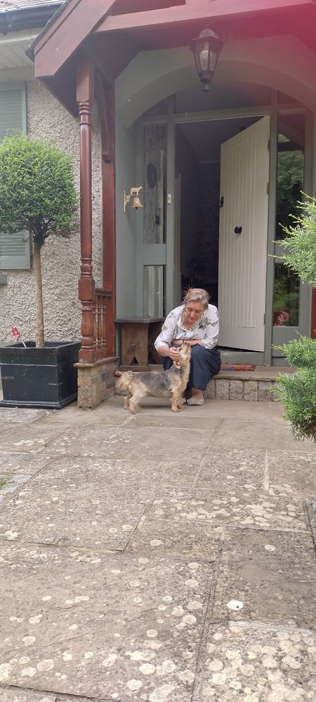 Ruth sitting on the doorstep petting the small dog