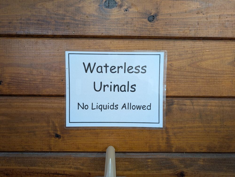 A sign on a bathroom wall reading "Waterless urinals
No liquids allowed"