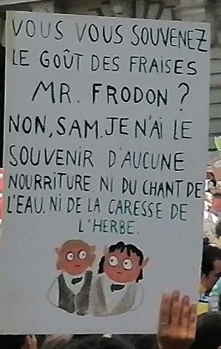 picture of hand painted protest sign with two hobbits and text in French about having forgotten what strawberries taste like