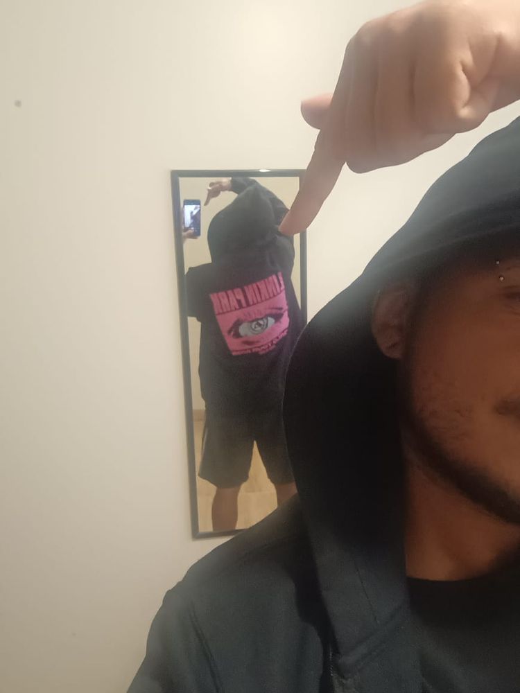 foto minha de costas, no espelho, mostrando a estampa de trás do casaco preto, com a ilustração em rosa escrito "Linkin Park" e uma um olho com o símbolo da banda na pupila