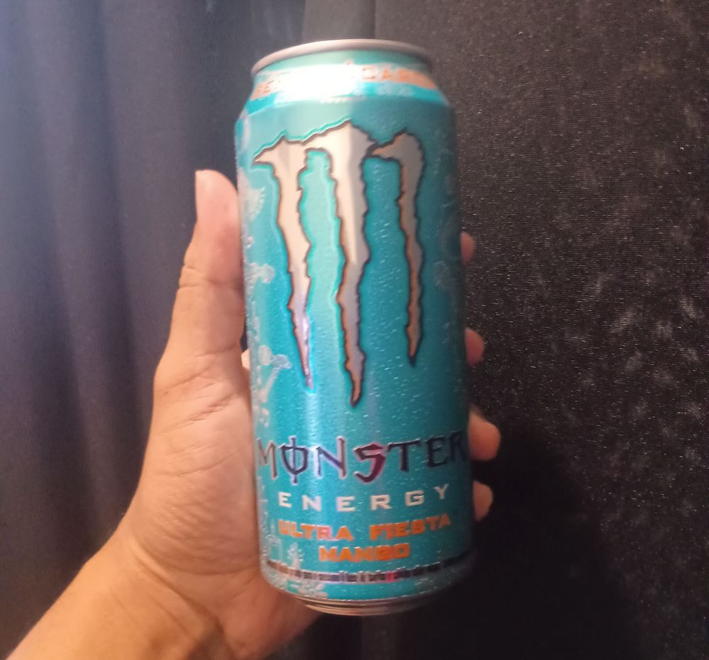 eu segurando uma lata de monster fiesta mango
