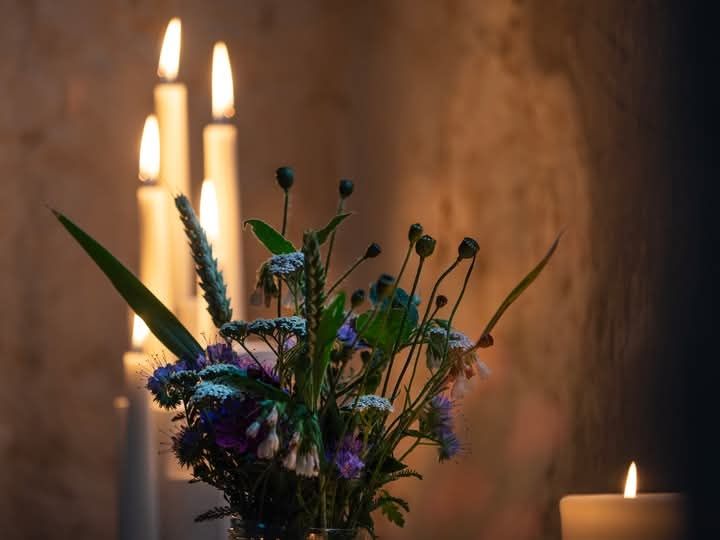 Fiori in un vaso e candele accese.