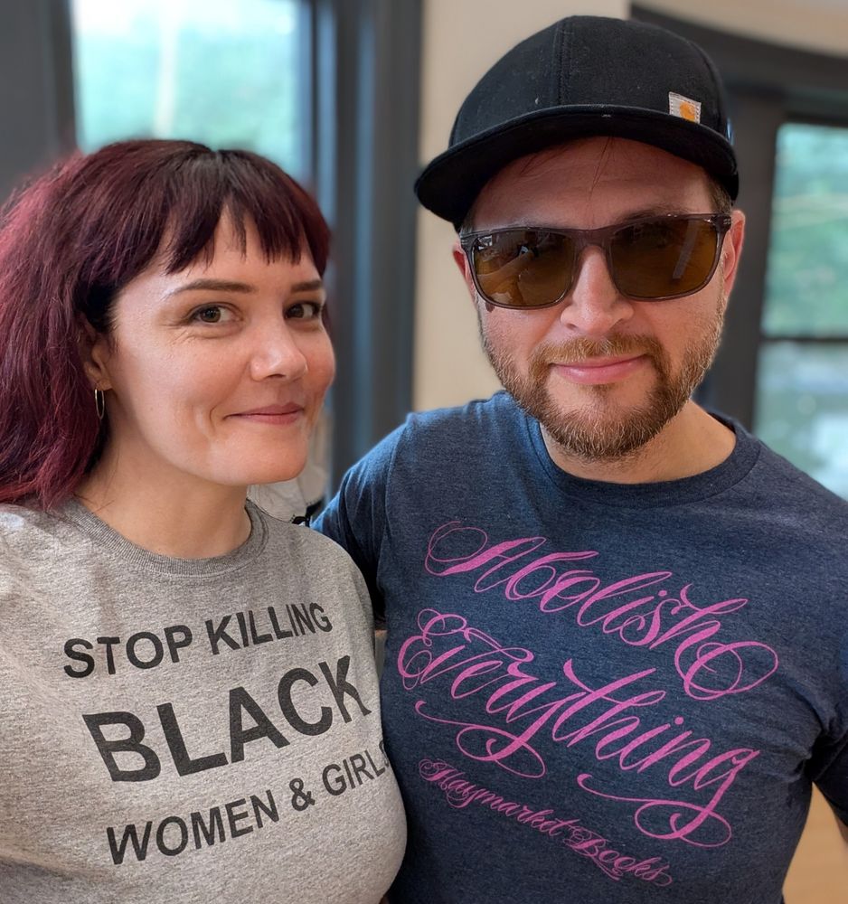 Me, in a tee that says STOP KILLING BLACK WOMEN & GIRLS, & Shane, in a tee that says Abolish Everything - Haymarket Books