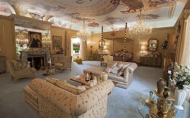 Liberace's bedroom room, a gilded space with multiple chandeliers, frescos, a marble fireplace, gold, gold gold.