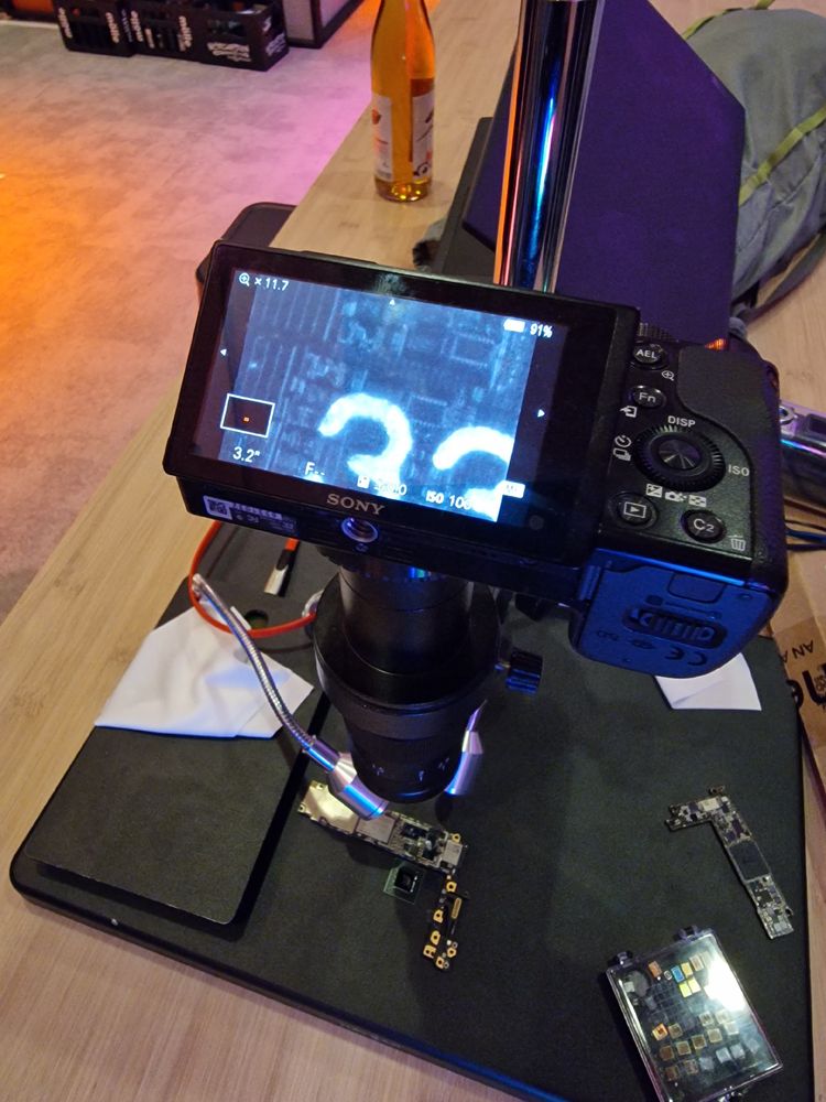 A full view of the setup, its a camera mounted to a basic microscope lens and an IR LED shining onto an iPhone motherboard