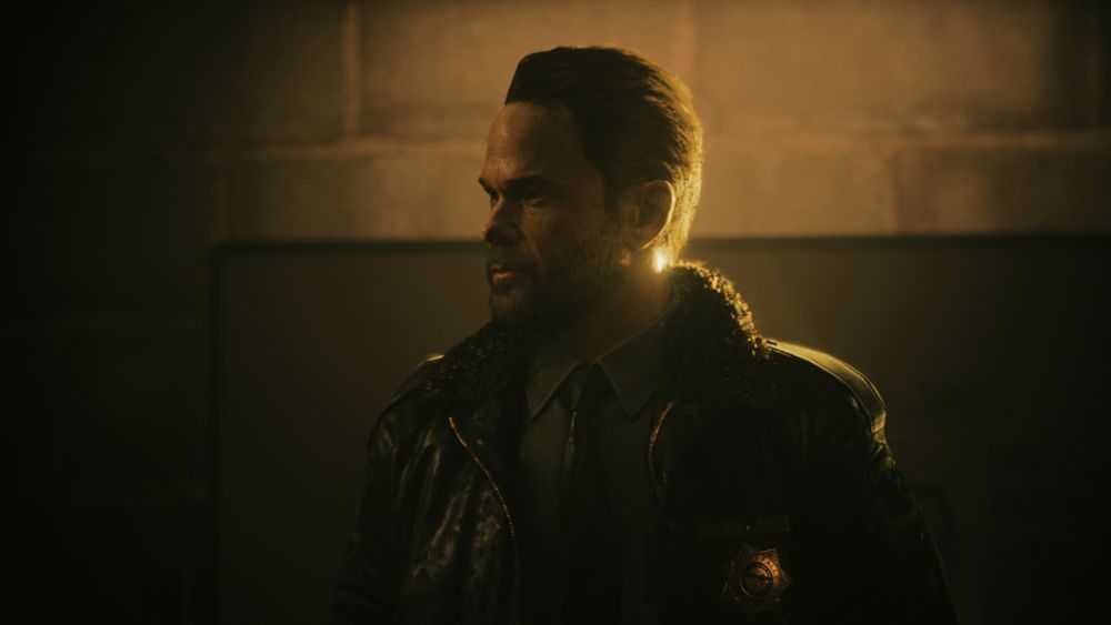 A screenshot of Tim Breaker from the game Alan Wake 2 with golden backlighting. 