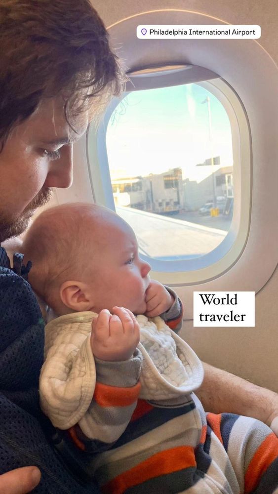 newborn sitting by an airplane window.