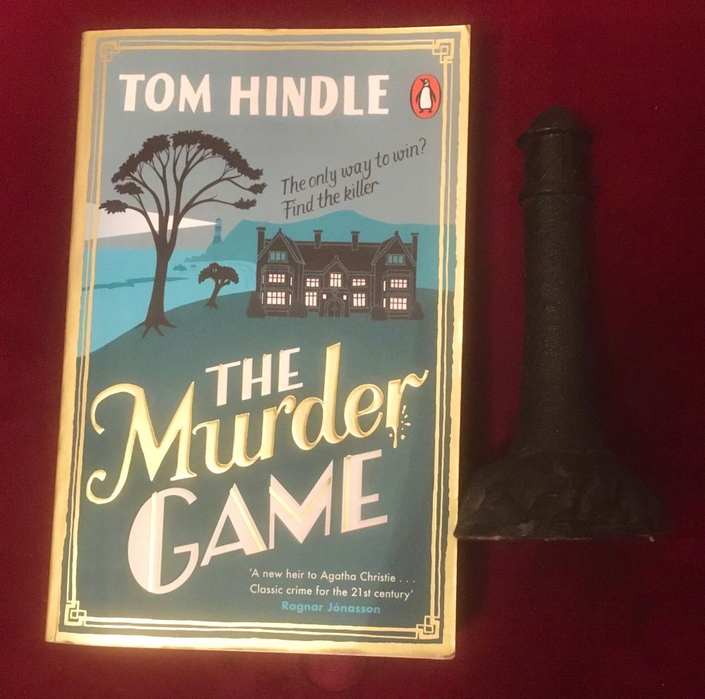 book cover of The Murder Game by Tom Hindle with a coal lighthouse alongside