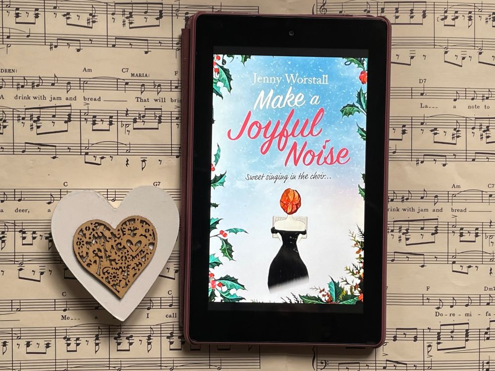 book cover of Make A Joyful Noise by Jenny Worstall on a music score with a heart ornament alongside