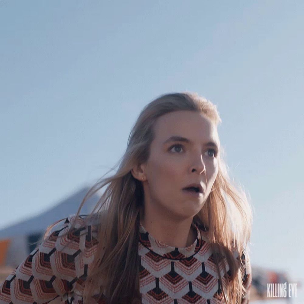 a close up of a woman 's face with a killing eve logo in the background