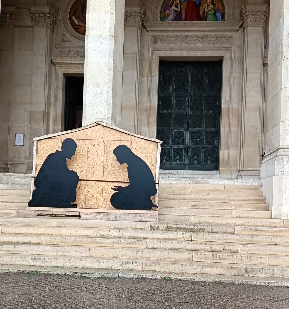 Devant église St Augustin , ce matin.
Un panneau de bois sur les marches 
Deux personnages agenouillés l un en face de l autre  habillés en noir.