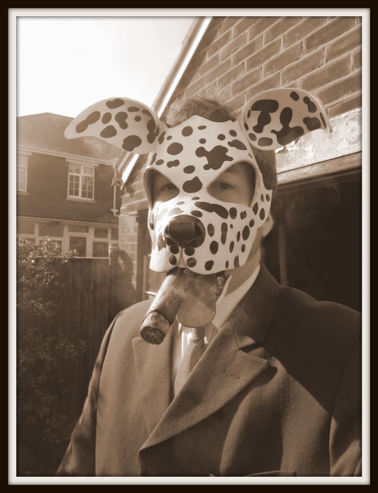 A black and white photo of Condor wearing the Spots Dalmatian hood, in a posh suit standing outside and smoking a large cigar. 