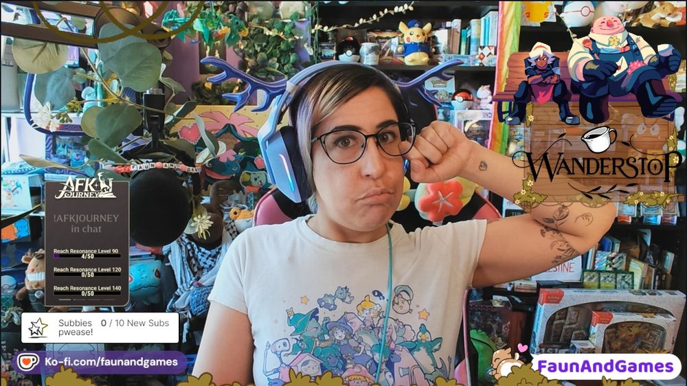 Nonbinary streamer FaunAndGames, a tan skin femme perceived person with brown, blue, and pink hair, is wearing gaming headphones with antlers on them. They are making a sad face camera with a Twitch sponsored stream setup around them and logos for AFK Journey