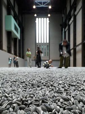 Low angle shot of Ai Weiwei sunflower seeds exhibit at the Tate Modern. Looks pretty surreal, with a carpet of ceramic sunflower seeds and blurry people in the background.
