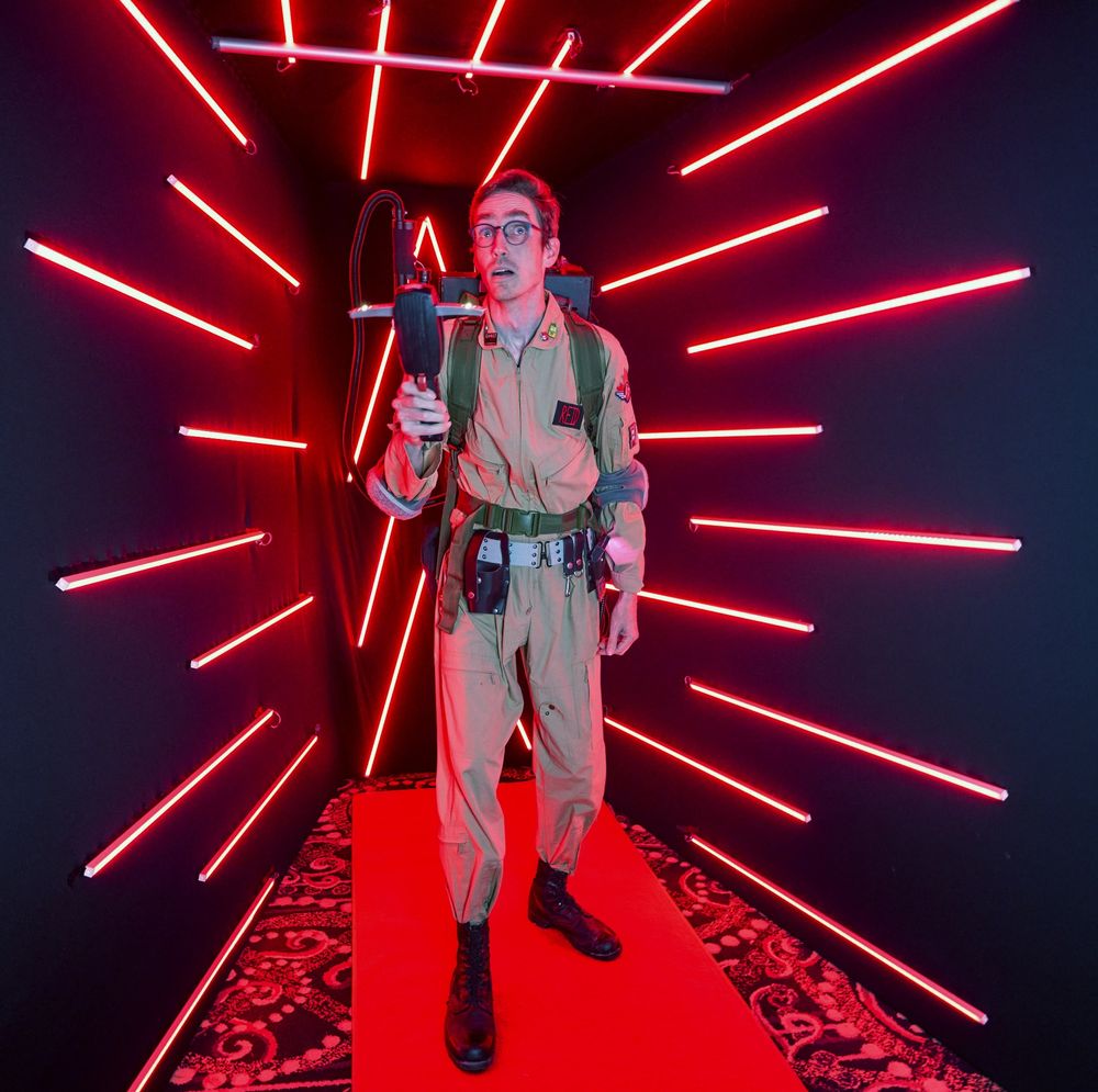 A man dressed in a full Ghostbusters uniform and gear. 