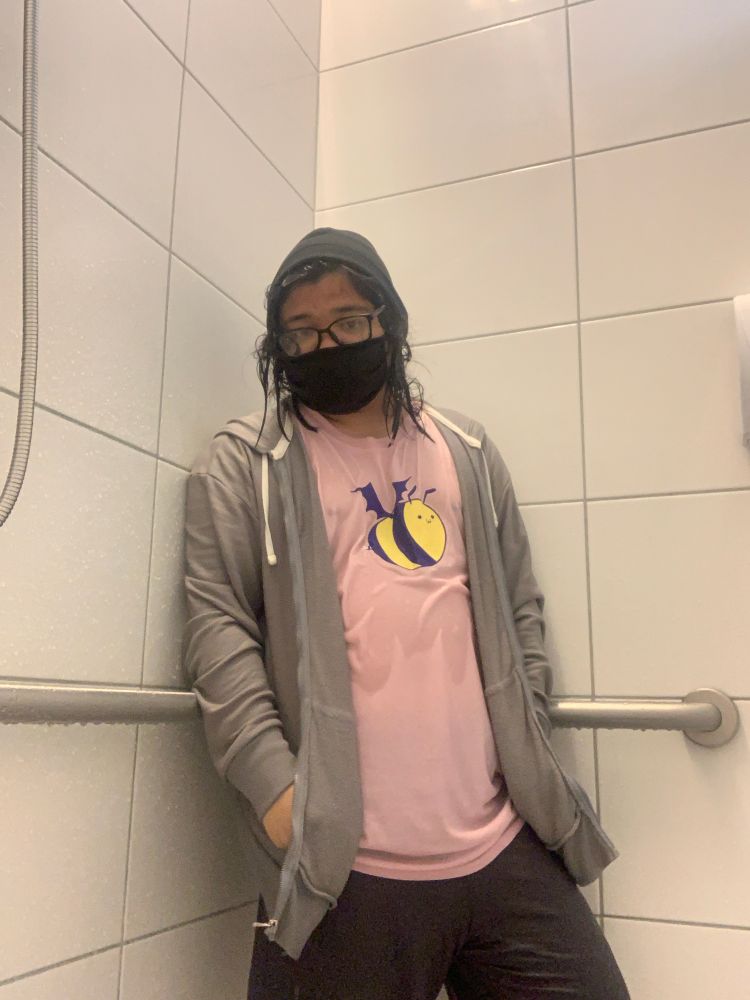 a shot of bxrc in the same place as before, but is now soaked with water, with their hands inside their wet jacket’s pockets