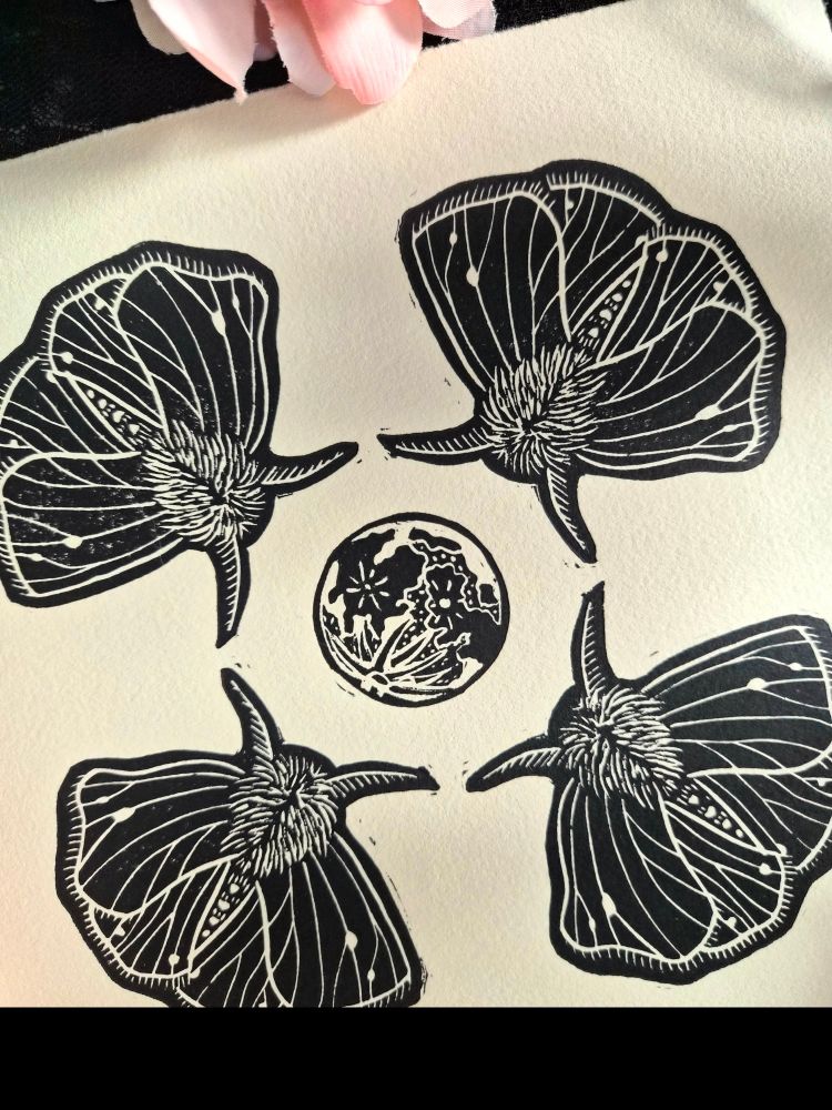 A close up of the moth and moon linocut print