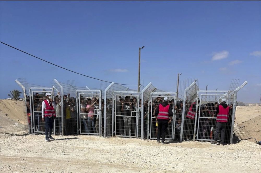 This photo, provided by an American contractor on condition of anonymity shows Palestinians crammed behind gates and fencing before entering a food distribution site operated by the Gaza Humanitarian Foundation in May 2025. Photo credit to AP.