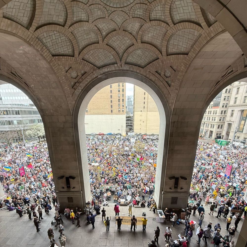 A crowd in 1000s is seen under the archways of a building in a main square in Pittsburgh