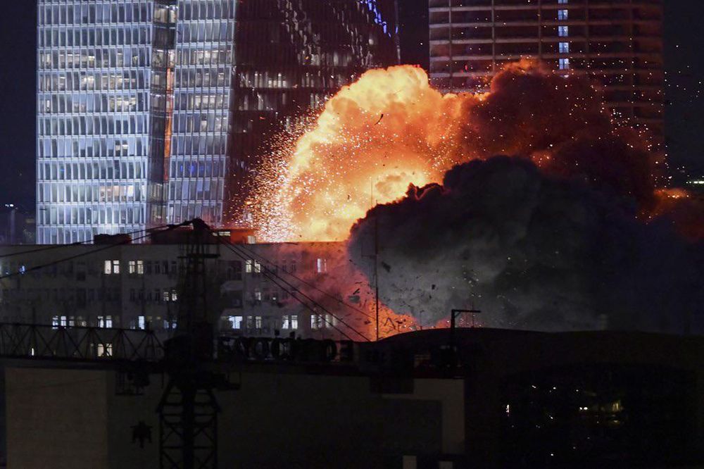 An explosion is seen during a missile attack in Tel Aviv, Israel, Friday, June 13, 2025. A fireball and dark black smoke is seen billowing from the impact, with high rise buildings, residential apartments and office lights seen all around. Credit to Tomer Neuberg for AP Photo.